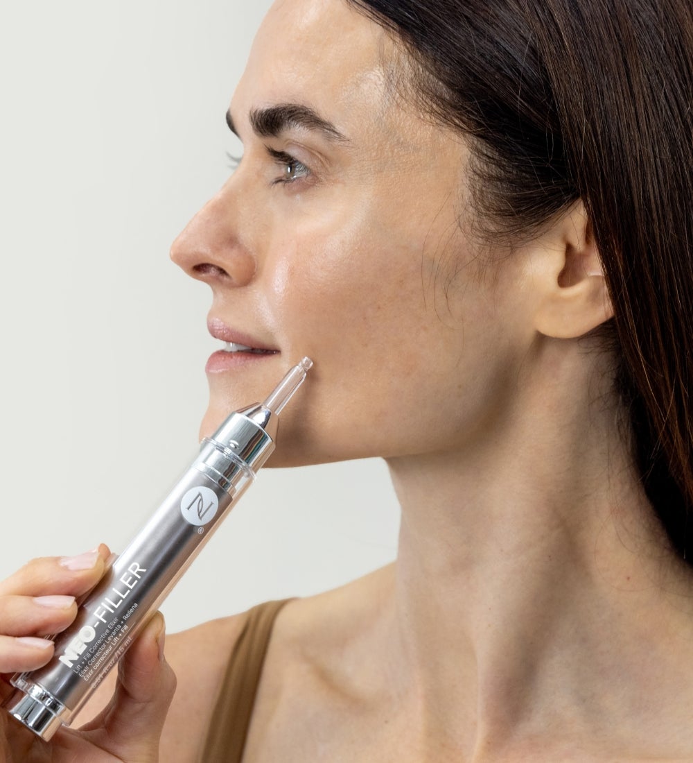 A woman applying Neo-FILLER to her cheek.